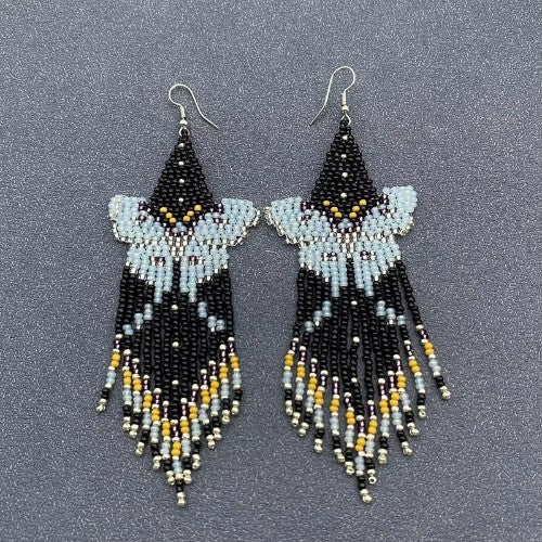 Beaded earrings with black, blue, and yellow beads on a gray background