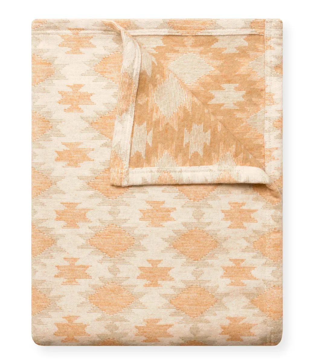 Woven blanket with geometric pattern on a white background