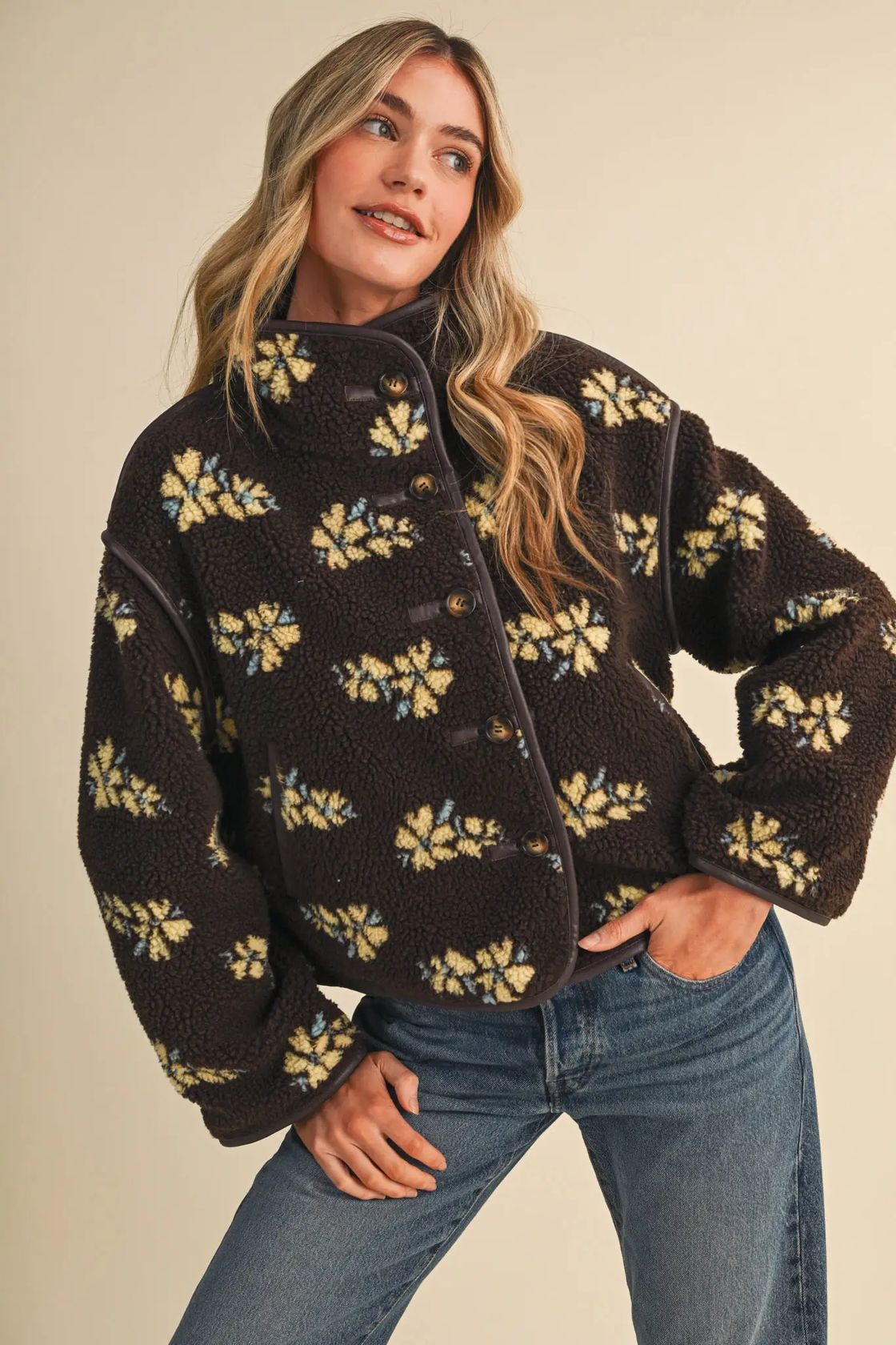 Woman wearing the &merci Floral Sherpa Jacket in brown with butter-yellow flowers and contrast piping, front view