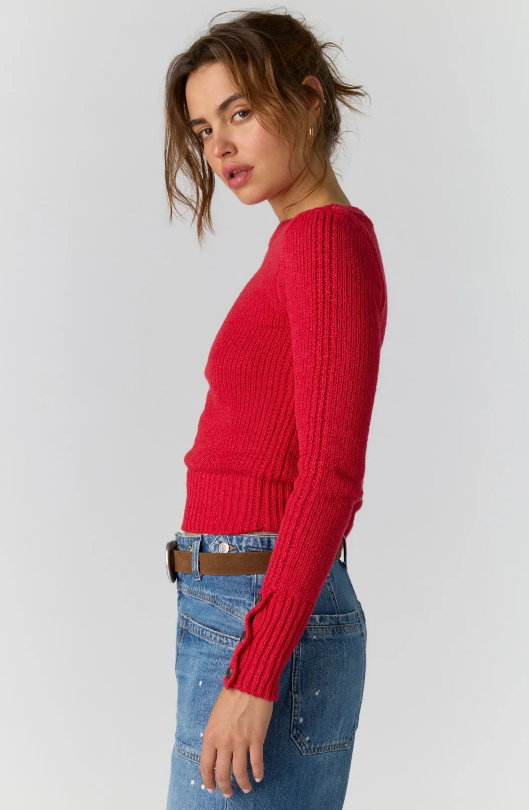 Side view of the Free People Mila Pullover in salsa red with long sleeves and button cuffs