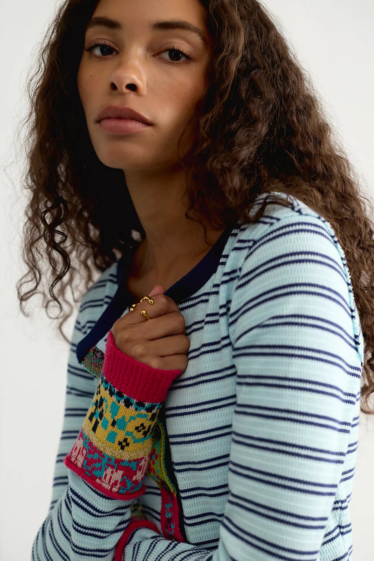 Close-up of the Free People We The Free Noa Cardi, a fitted light blue and navy striped cardigan with navy crew neck trim and pink multicolor embroidered cuffs