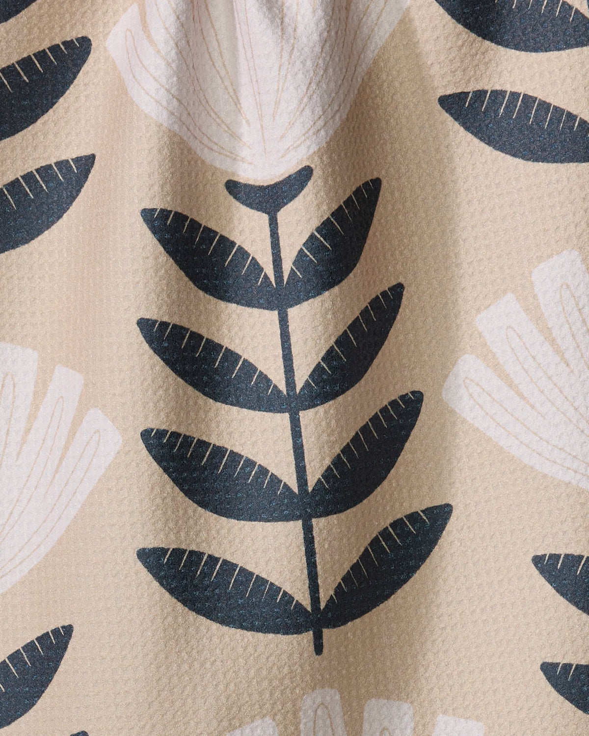 Close-up of the Geometry Gloria tea towel black leaf stem print on sand