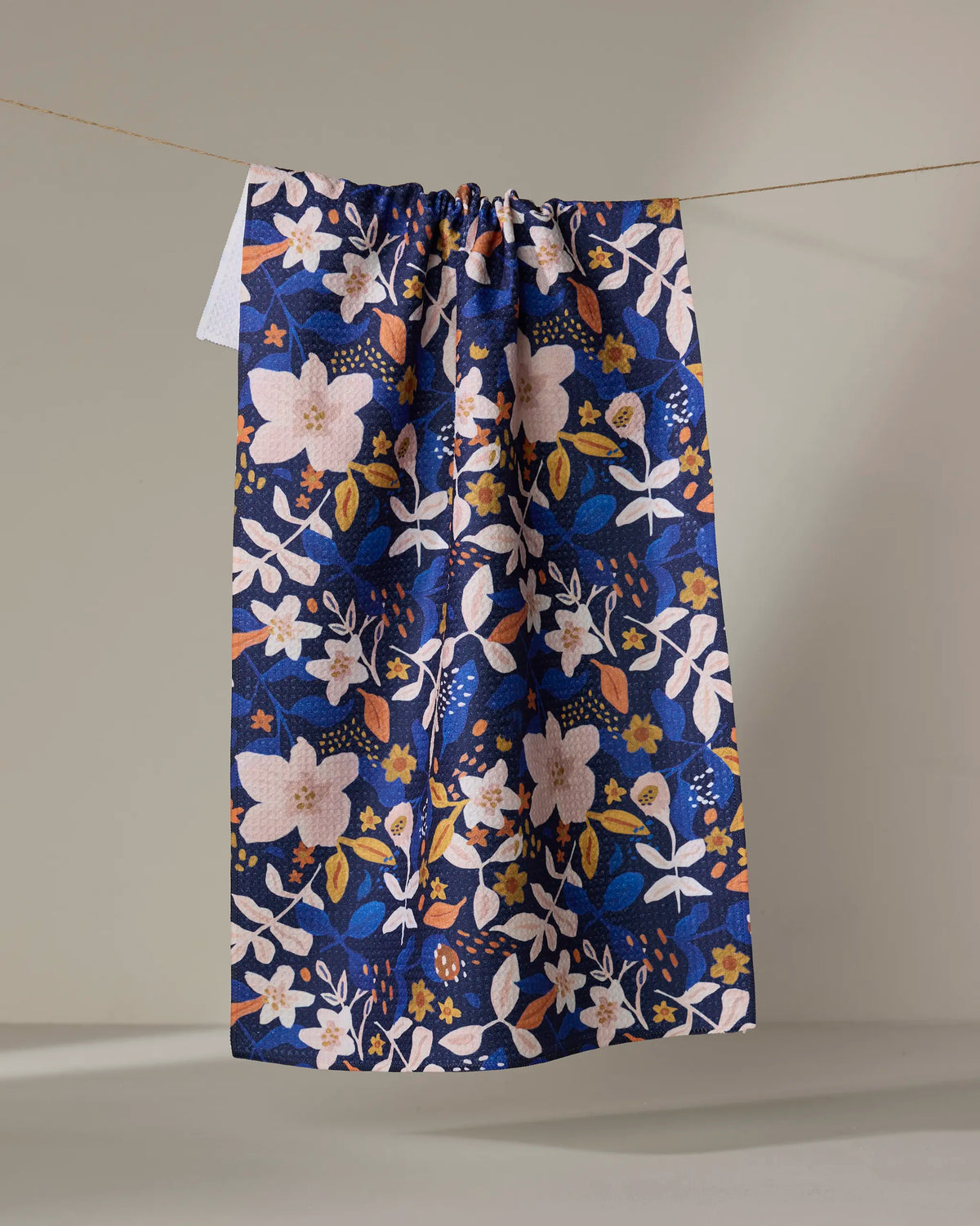 Geometry Nightfall Garden tea towel laid flat with blush and cream florals on deep navy