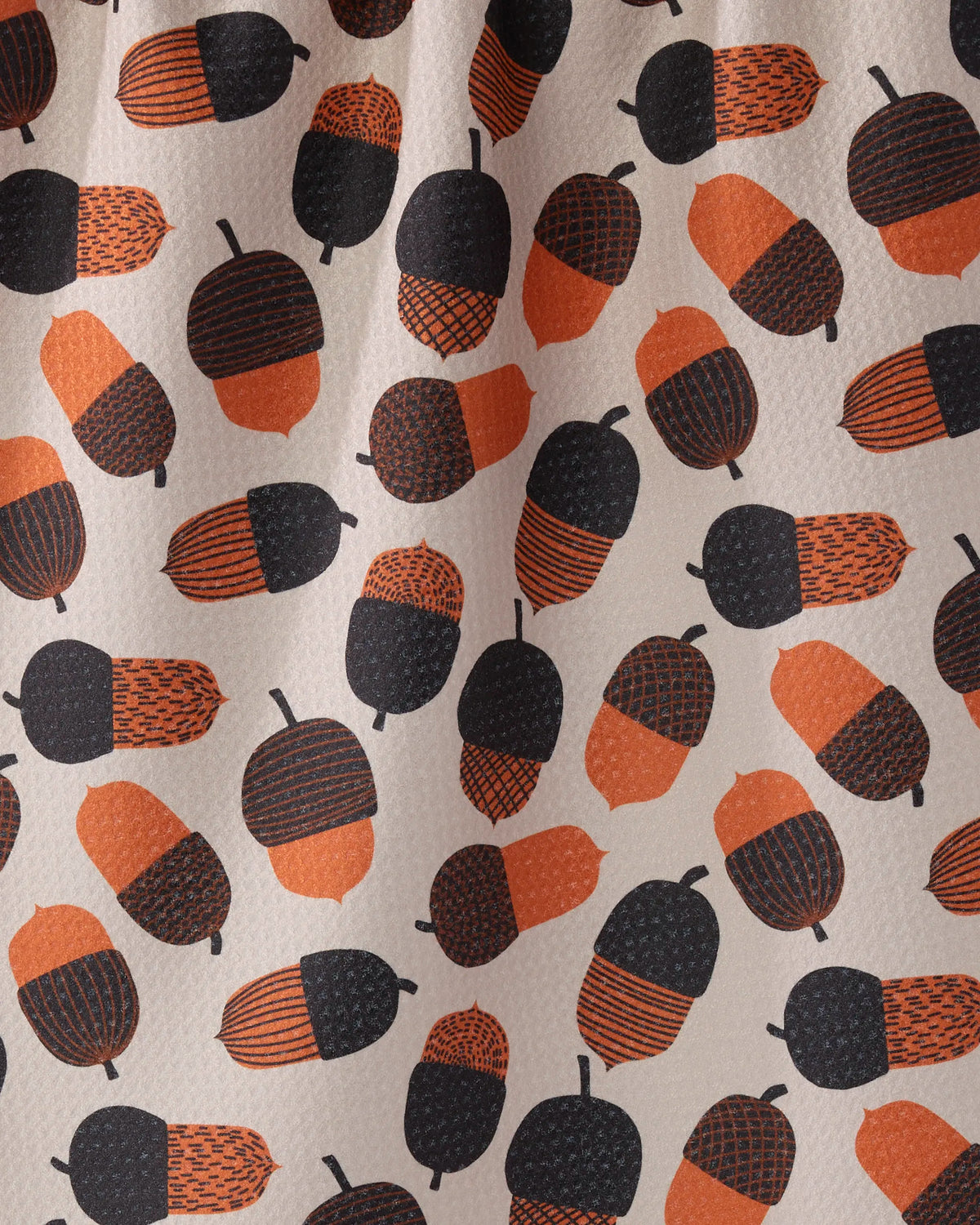 Close-up of the Geometry Squirrel Bounty tea towel acorn print in orange, brown and charcoal on cream