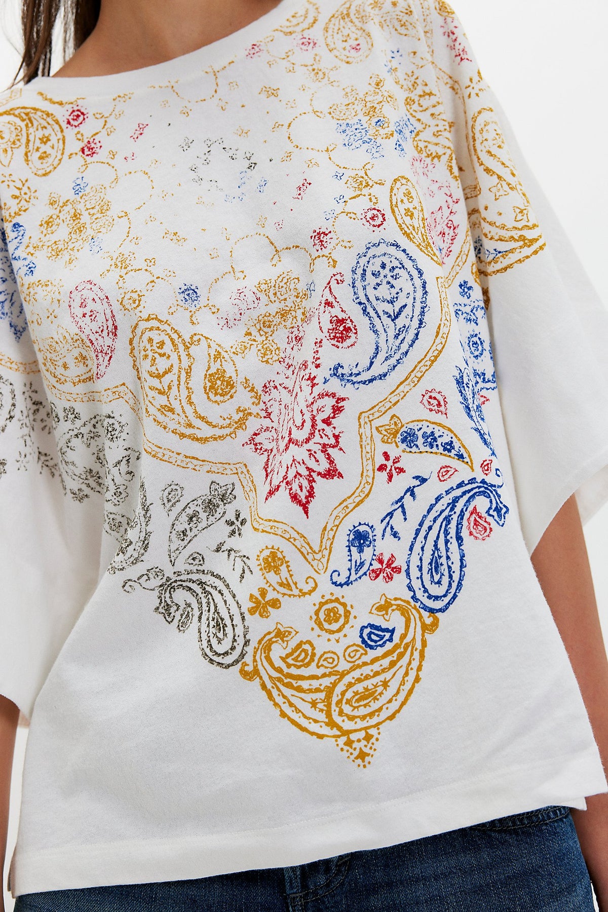 White t-shirt with colorful paisley pattern worn by a person