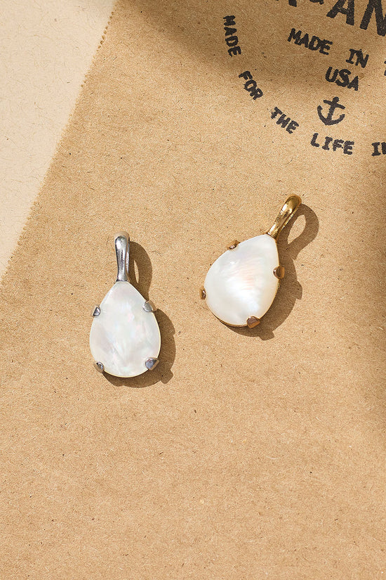 Two teardrop-shaped earrings on a beige background with text.