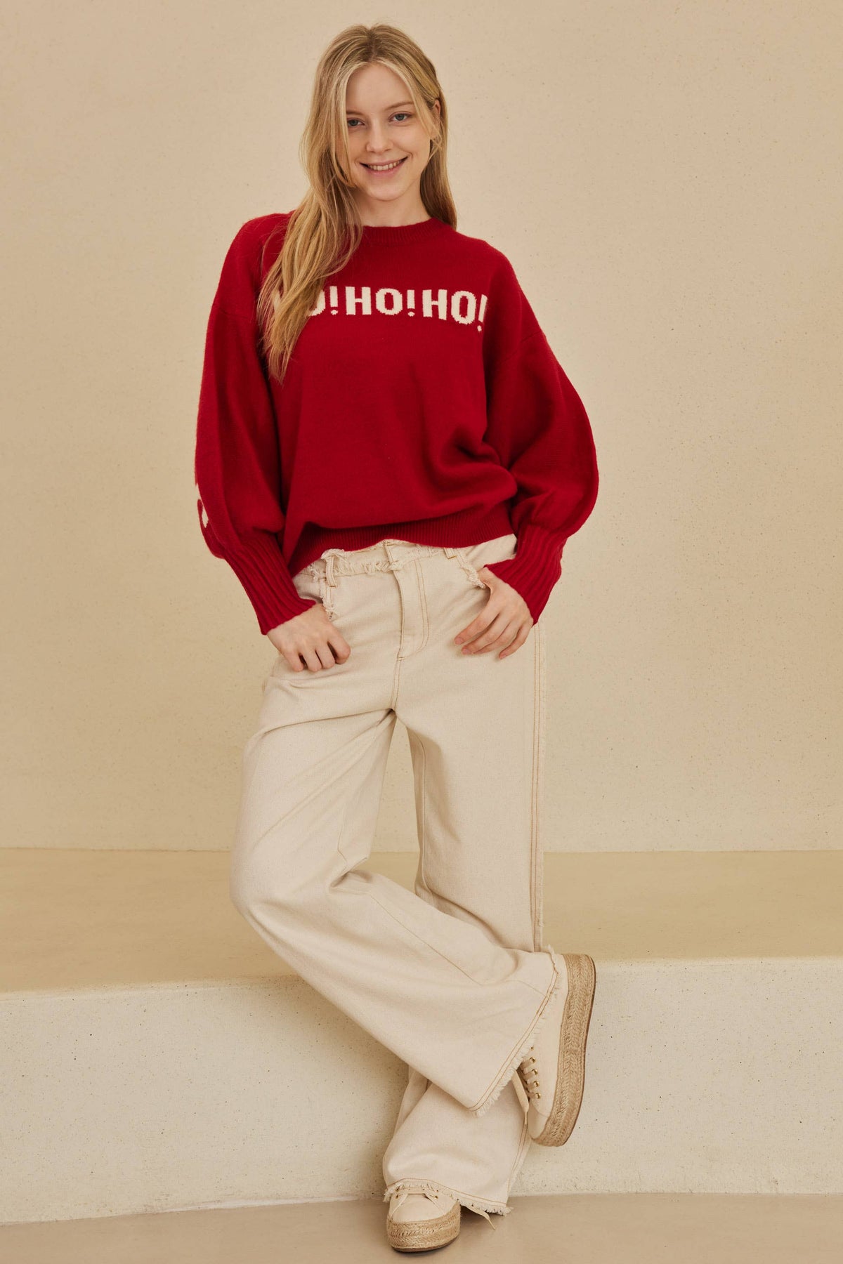 Model in the Red Merry Christmas Sweater and cream wide-leg pants, full-length view