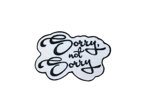 Black and white embroidered Sorry, Not Sorry script iron-on patch