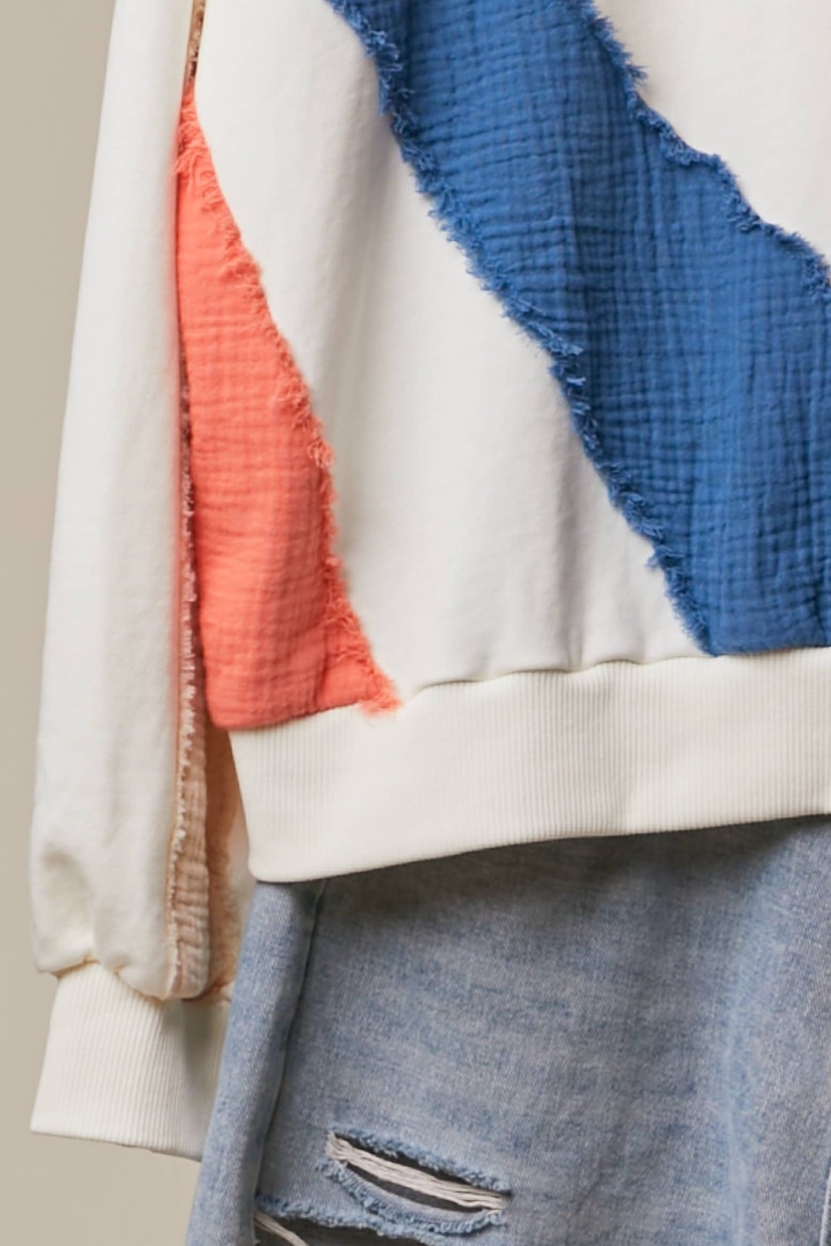 Close-up of the Sun Patchwork Sweatshirt showing cobalt blue and ivory mixed-fabric panels