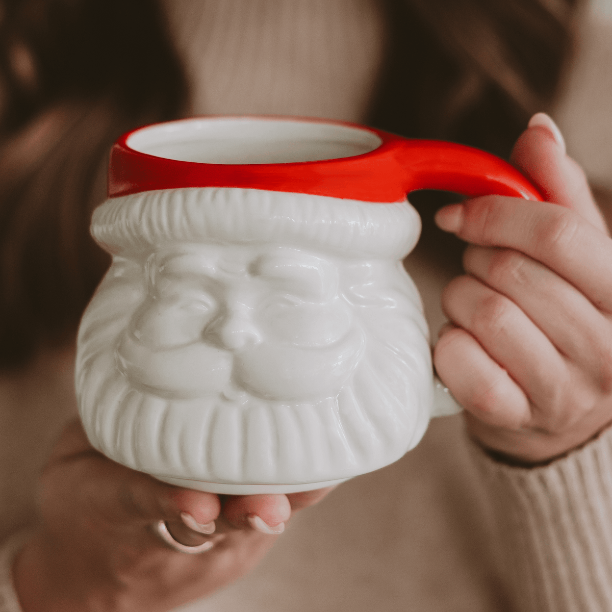 Hands holding the Sweet Water Decor Red Hat Santa 19 oz coffee mug with red handle