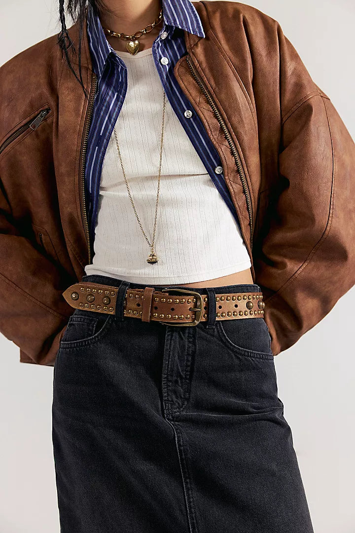 We The Free Sola Stud Belt in cognac leather worn at the waist over dark denim with a brown leather jacket