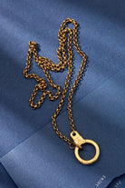 Gold chain necklace on a blue textured background