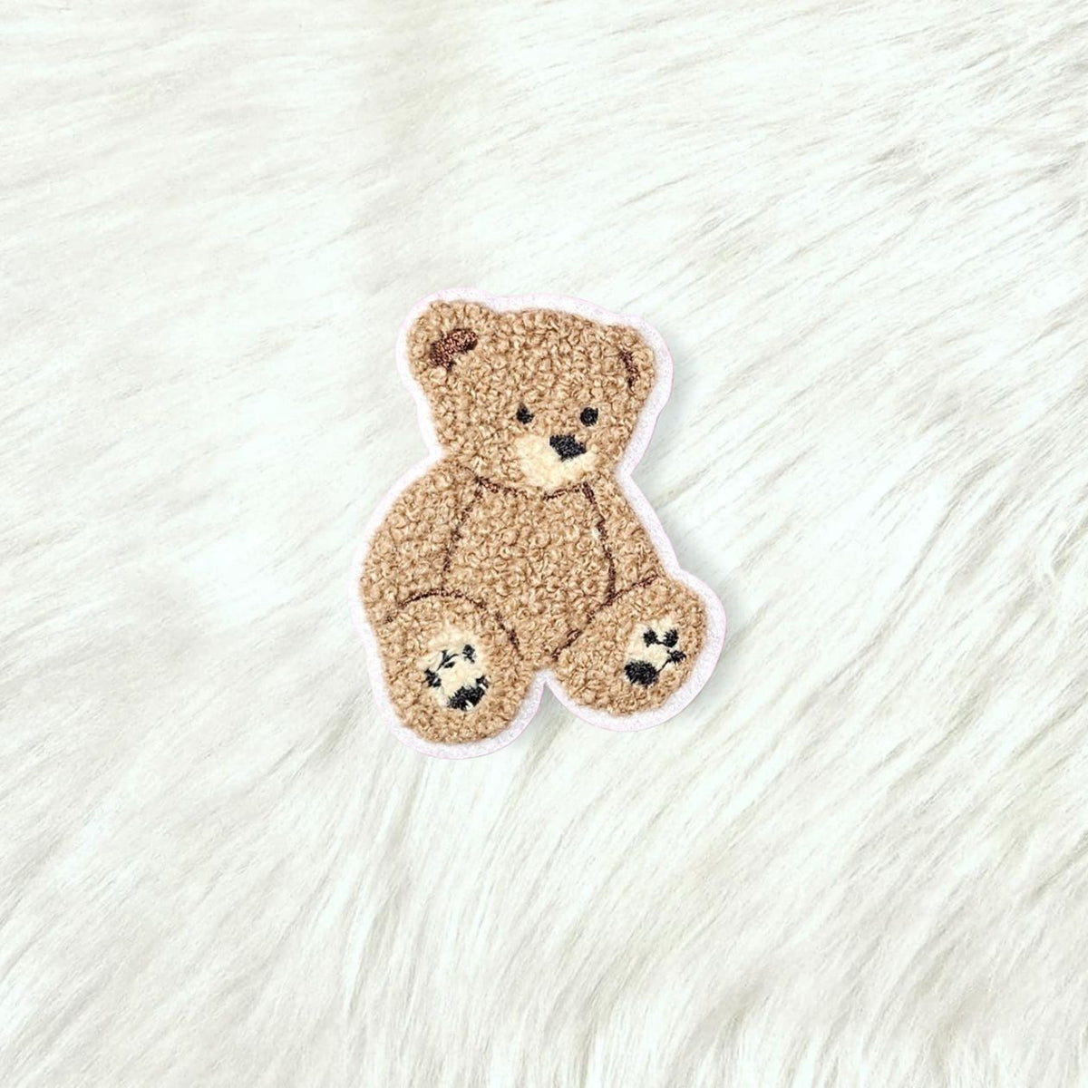 Teddy bear-shaped rug on a textured white surface