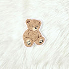 Teddy bear-shaped rug on a textured white surface