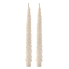 A pair of tall, narrow white taper candles with a layered, ruffled texture, shown against a plain white background.