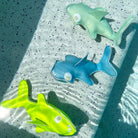Three colorful shark-shaped objects on a textured surface