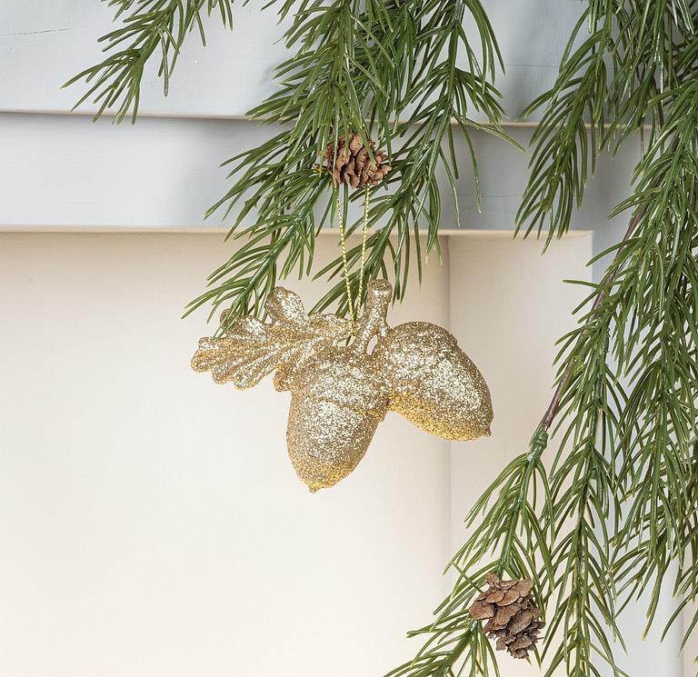 Abbott gold glitter acorns ornament on an evergreen branch