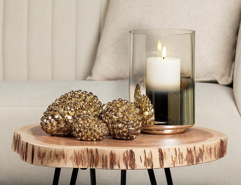 Abbott medium antique gold pinecones styled on a wood side table with a candle