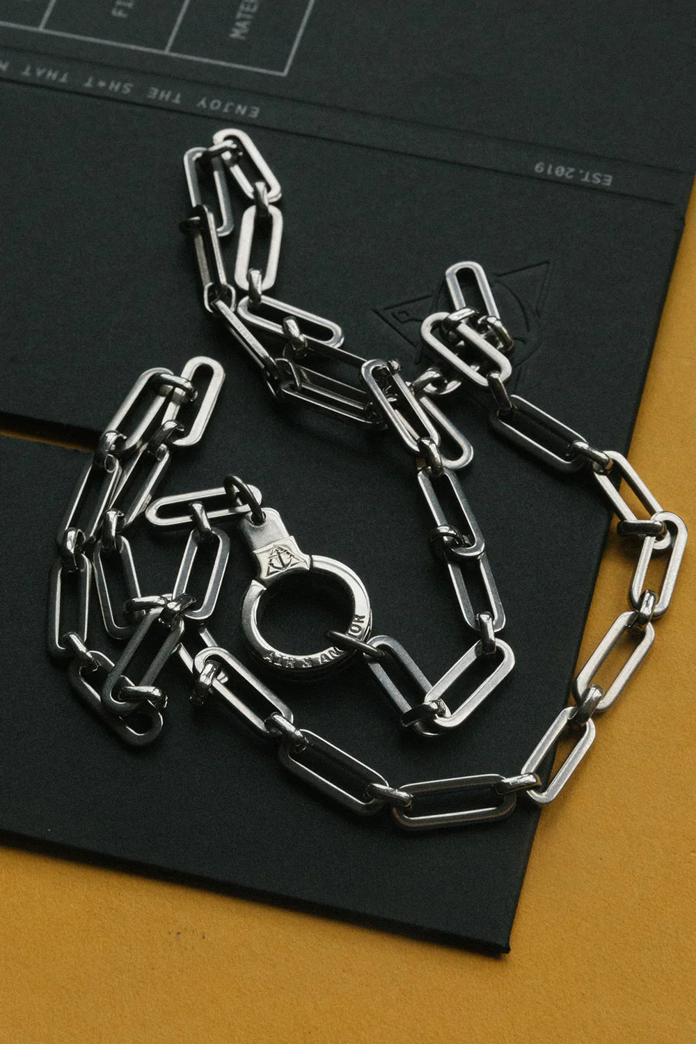 Silver chain and handcuffs on a black surface
