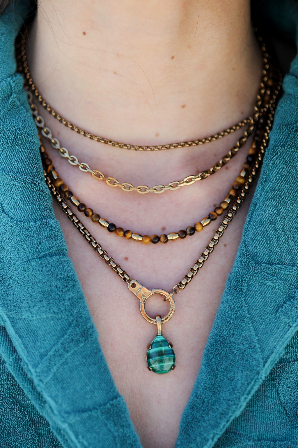 Model wearing the Air and Anchor Endgame cuff keeper necklace layered with pendants