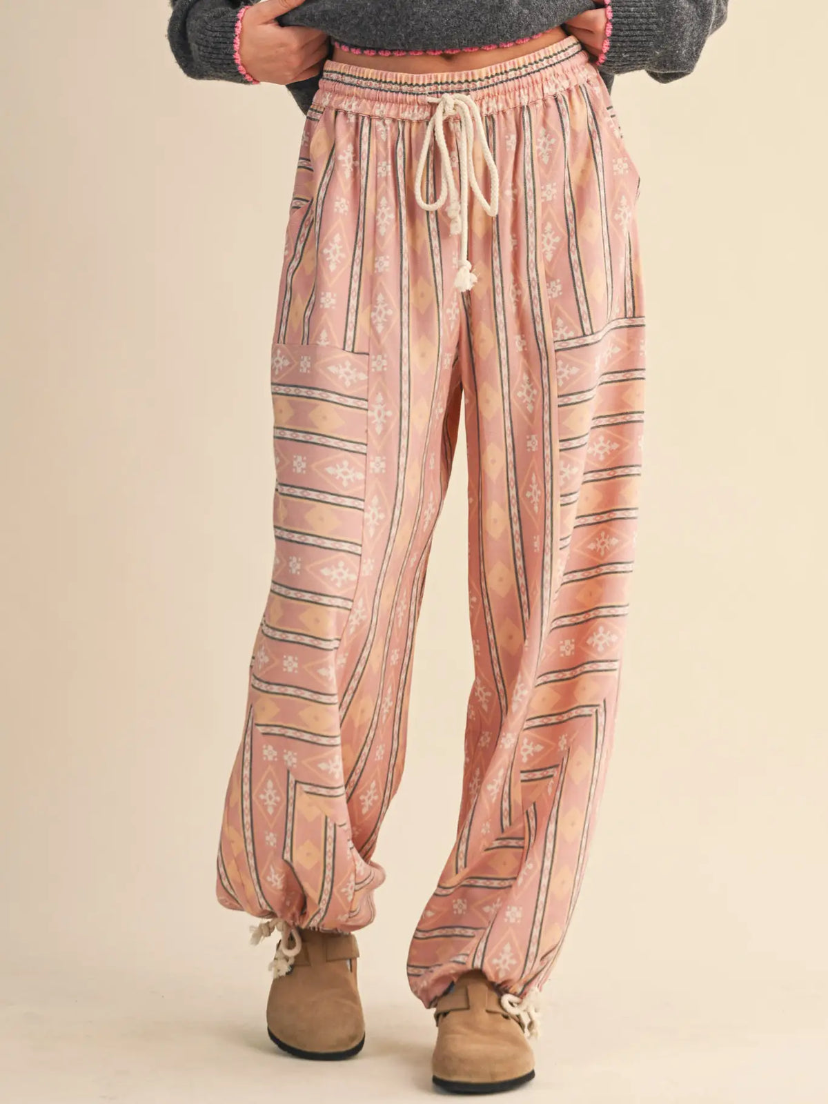 Front view of the &merci Aztec Parachute Pants in blush multi Aztec print with drawstring waist and wide leg