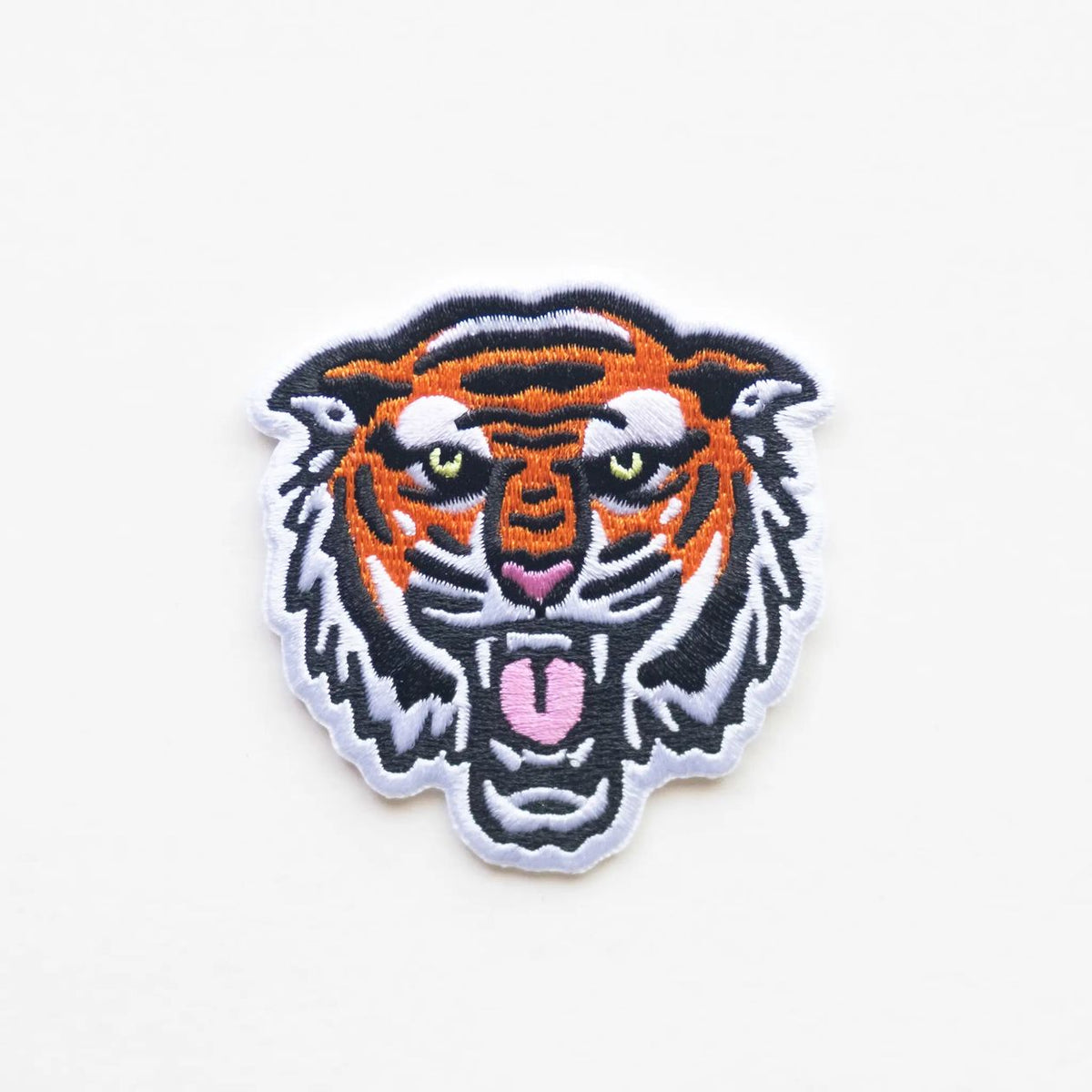 Embroidered patch of a tiger's face on a white background