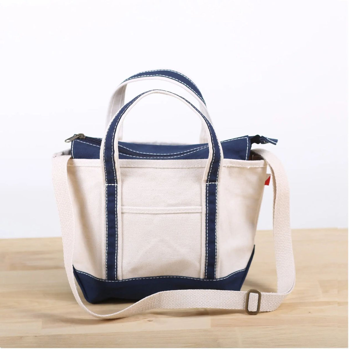 White tote bag with blue accents on a wooden surface