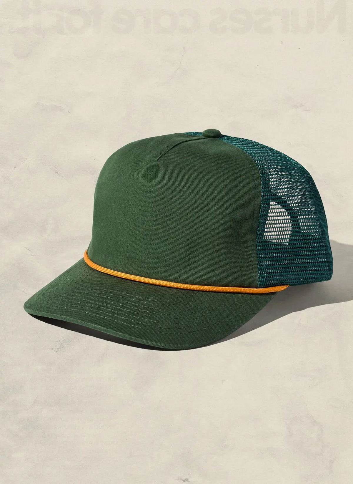 Hunter green brushed cotton trucker hat with mesh back and gold rope across the brim