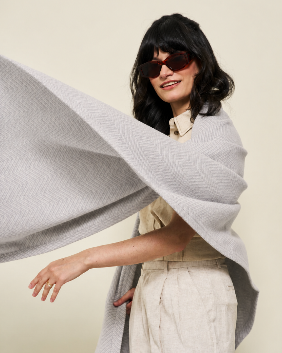 Woman wearing the Chappywrap Bayside Herringbone Shawl in Light Grey as an open wrap