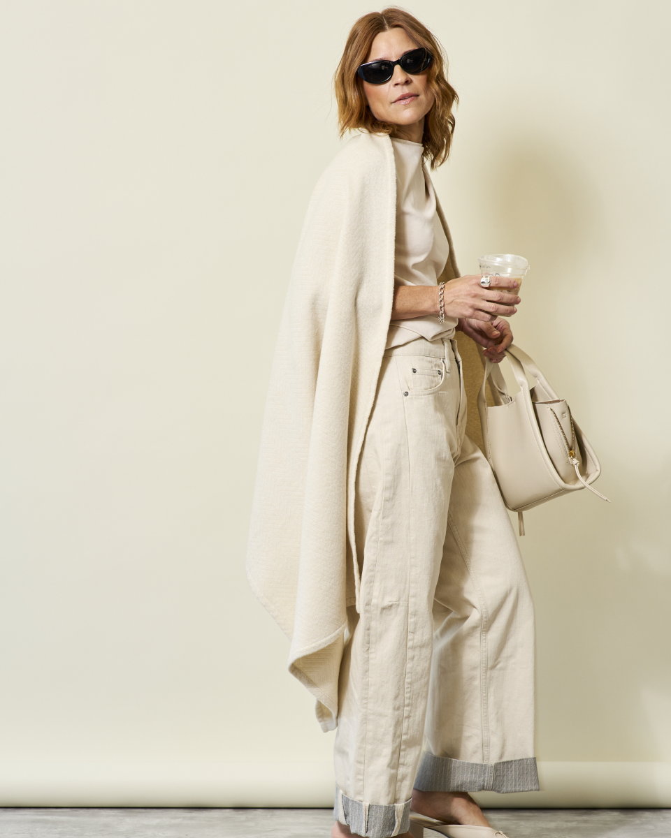 Woman wearing the Chappywrap Bayside Herringbone Shawl in Shell over a cream outfit