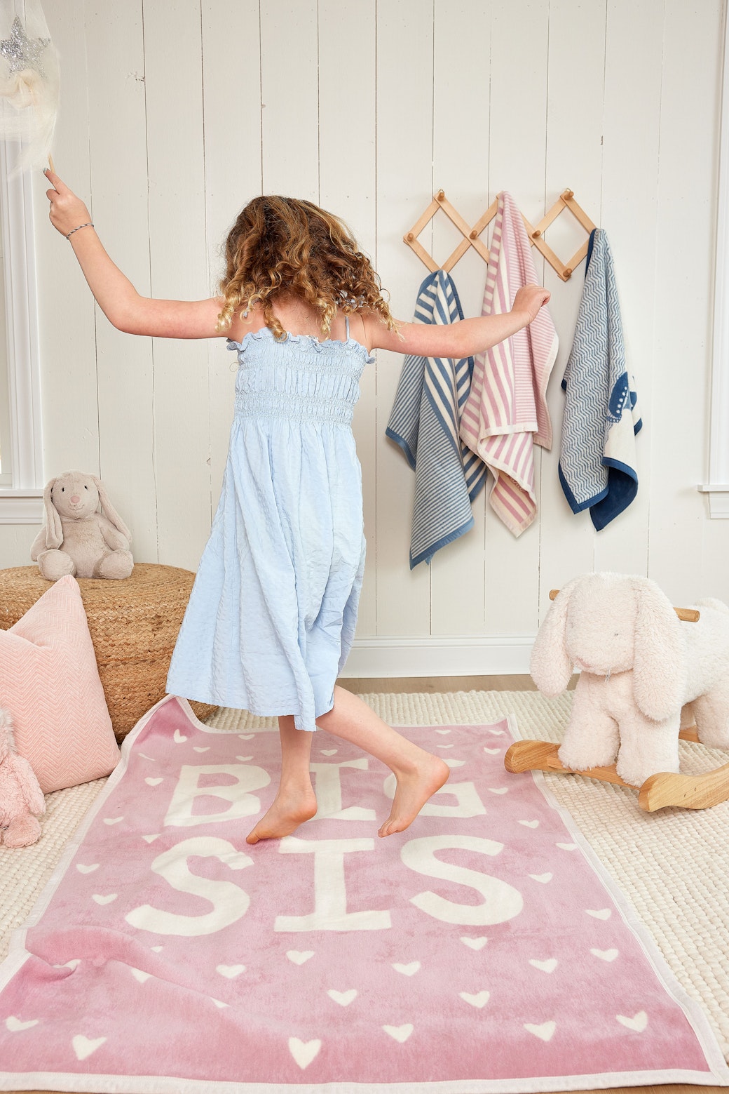 Girl dancing on the Chappywrap Big Sis Midi Blanket in a playroom
