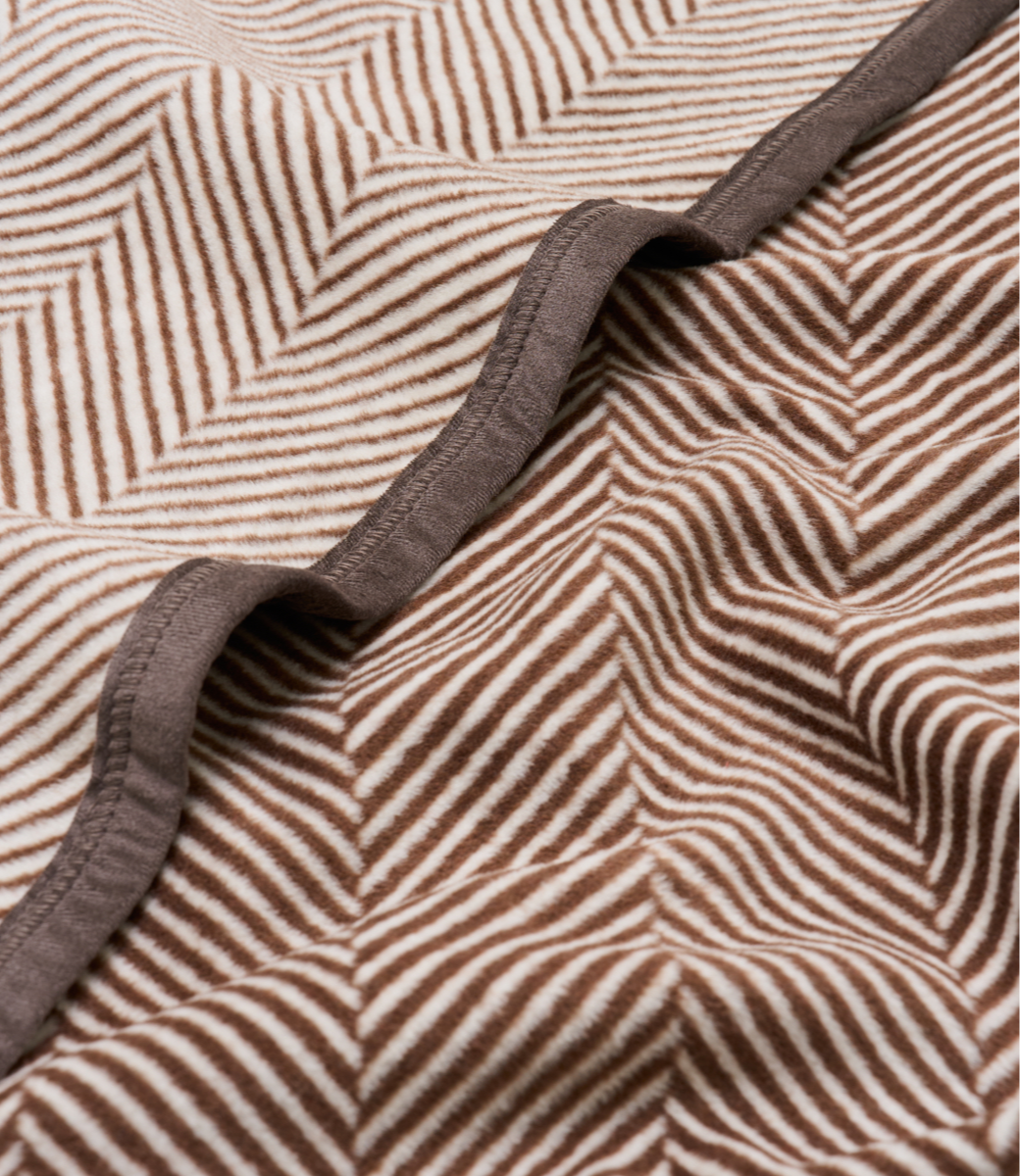 Close-up of the herringbone knit and border on the Harborview Herringbone Midi Blanket in Chocolate