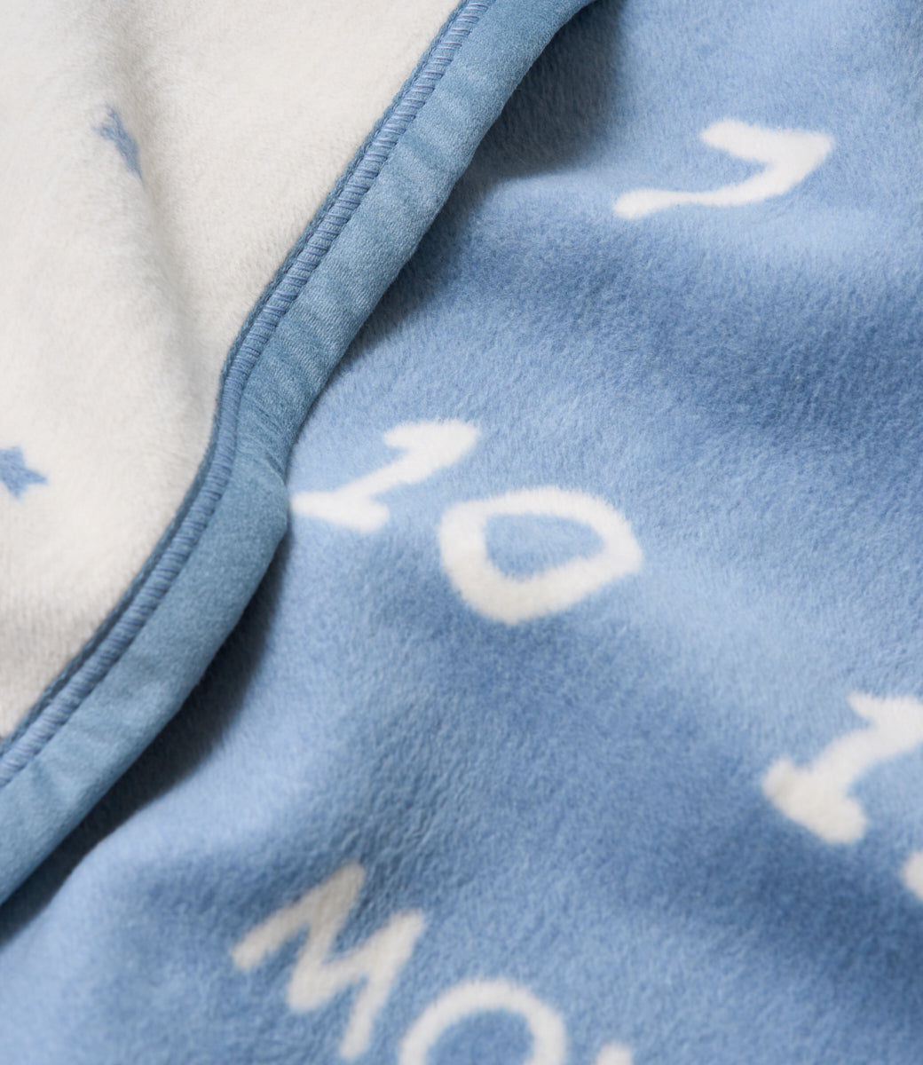 Close-up of the soft cotton-blend knit and woven numbers on the Chappywrap Milestone Mini Blanket in Fog