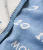 Close-up of the soft cotton-blend knit and woven numbers on the Chappywrap Milestone Mini Blanket in Fog
