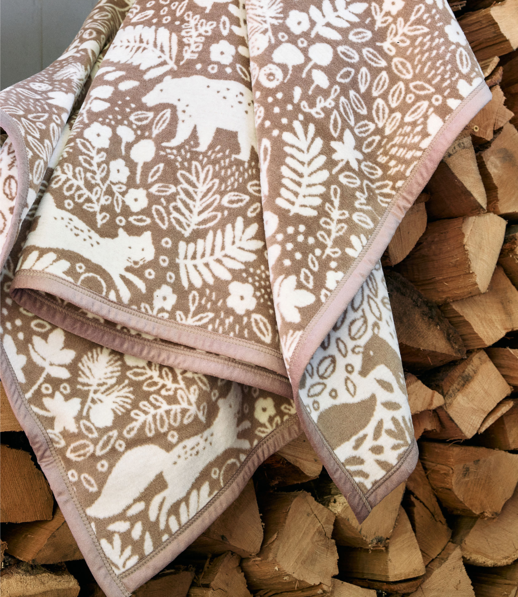 Chappywrap Whimsical Woods Blanket in Sepia draped outdoors, showing the woodland pattern