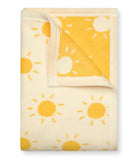 Folded blanket with sun pattern on a white background