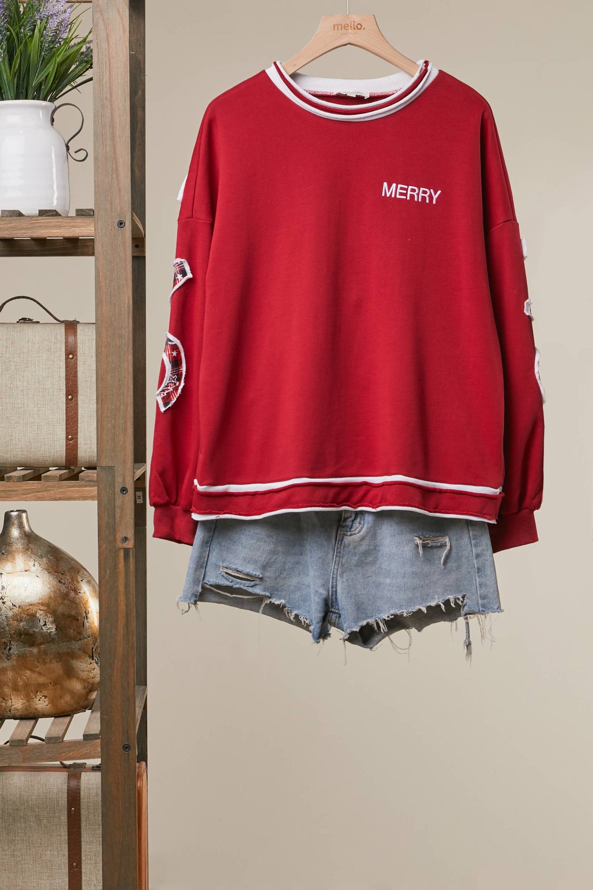 Front of the red Christmas Patchwork Letter Sweatshirt with white contrast tipping and small Merry lettering