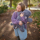 Girl hugging a Chubbees 22 inch weighted plush hippo in soft gray curly fur with pink ears