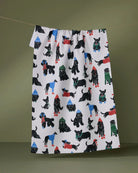 Dogue Magazine tea towel with stylish dogs in colorful coats on a white background hanging on a line
