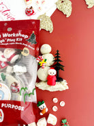 Earth Grown KidDoughs Santa's Workshop KidDough Play Kit contents spread out: play dough, Santa figure and holiday accessories