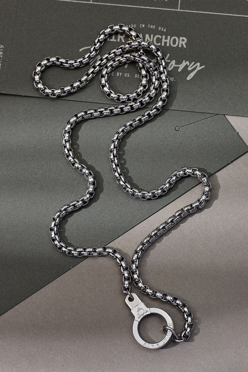 Silver chain necklace with clasp on a gray surface