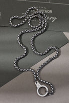 Silver chain necklace with clasp on a gray surface