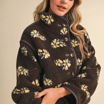 Woman styling the &merci Floral Sherpa Jacket in brown with butter-yellow flowers, three-quarter view