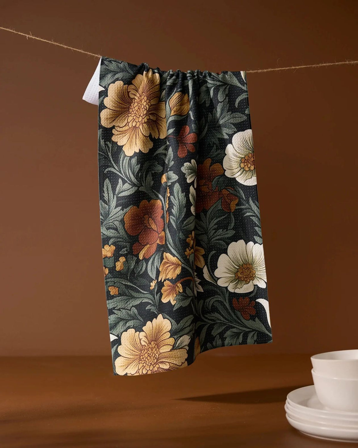 Floral-patterned pants hanging on a line against a brown background