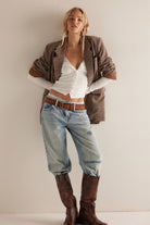 Model wearing the End Game Pointelle top in Sugar Swizzle with light-wash jeans, a brown jacket and tall boots