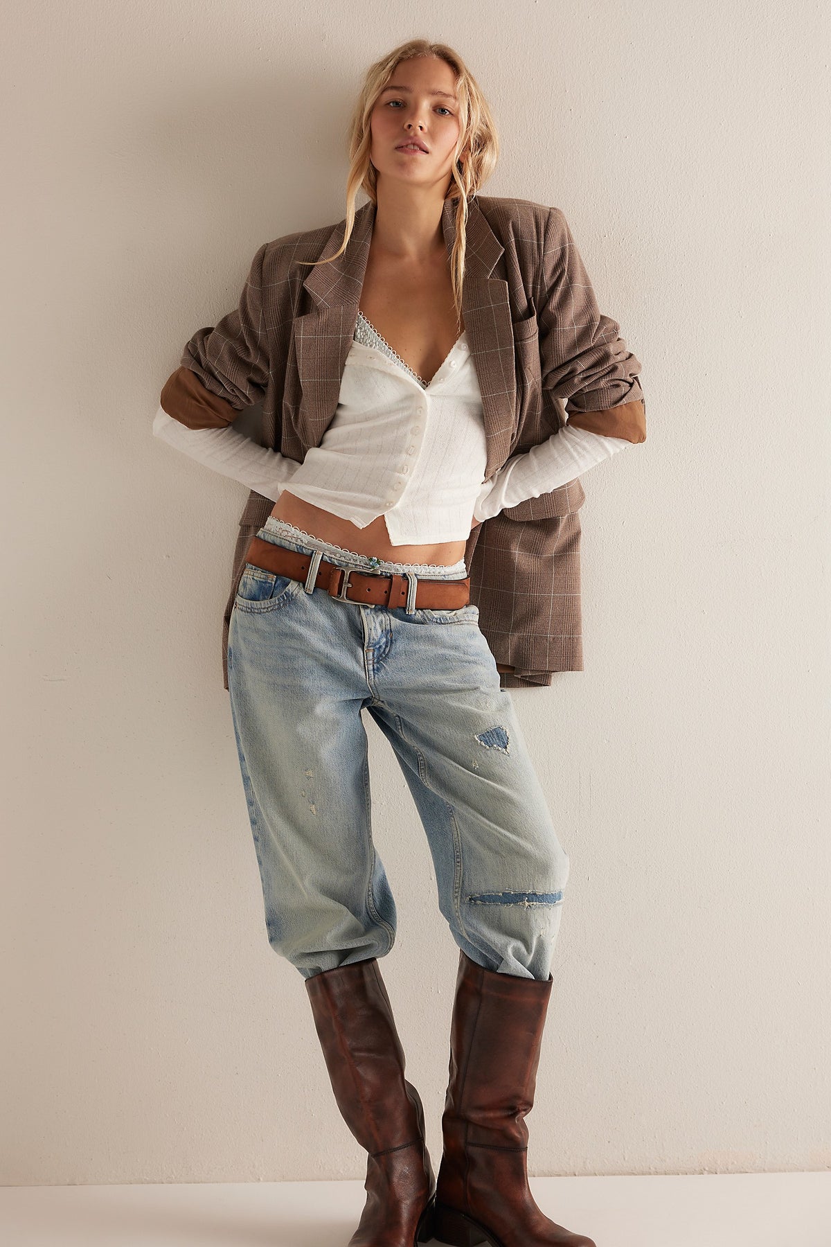 Model wearing the End Game Pointelle top in Sugar Swizzle with light-wash jeans, a brown jacket and tall boots