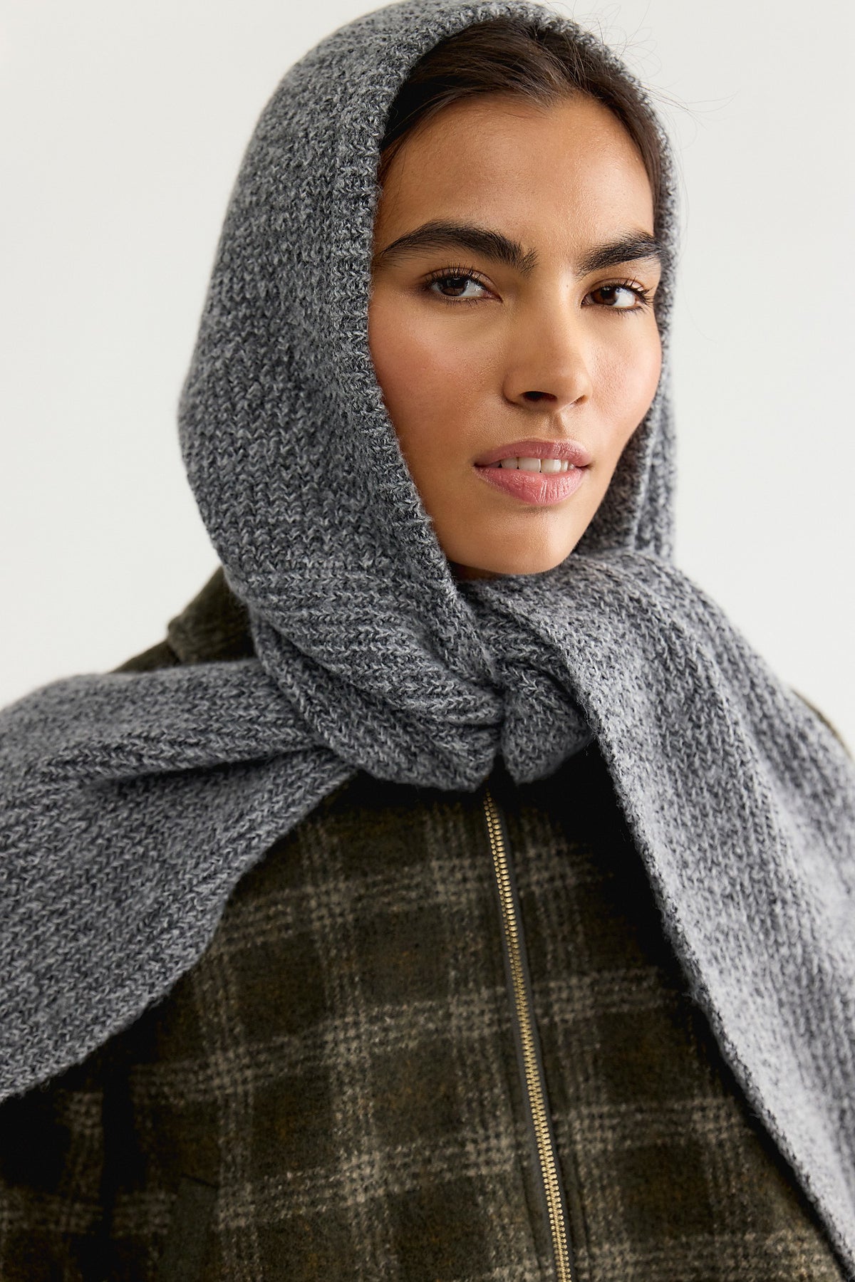 Model wearing the Free People Extra Large Balabonnet in grey with the hood up over a plaid jacket
