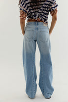 Model wearing We The Free Fable Low-Rise Twisted Seam Jeans in Art School with a striped top, full-length front view