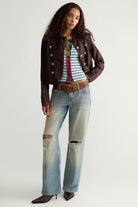 Model wearing the We The Free Noa striped cardigan in blue with a brown jacket and light-wash jeans, full-length