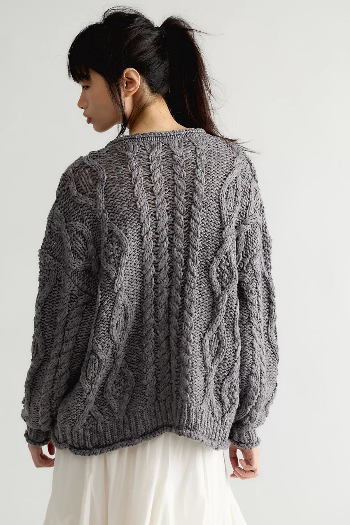 Back view of the Free People Opal Cardigan in steel grey, showing the oversized fit, dropped shoulders, and all-over chunky cable knit